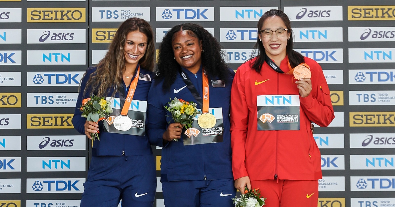 Valarie Allman, Laulauga Tausaga Collins, and Bin Feng on the podium at the 2023 World Athletics Championships.
